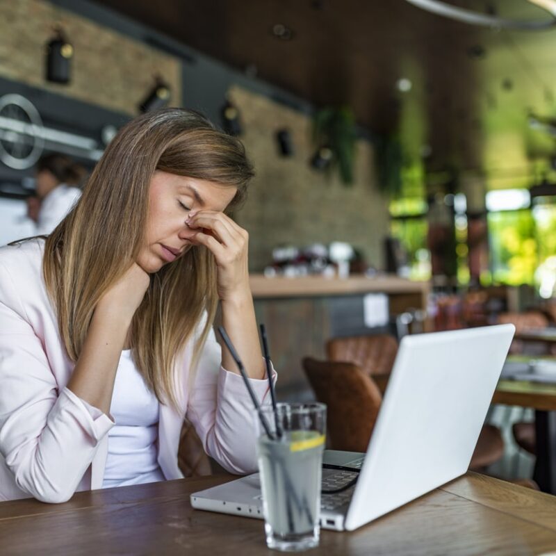 Financial Challenges Women in Cafe on laptop