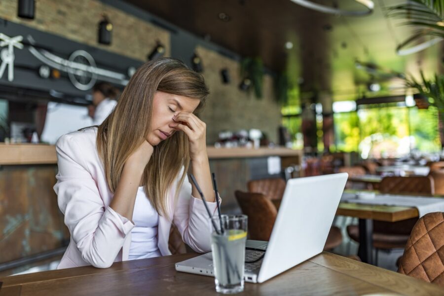 Financial Challenges Women in Cafe on laptop